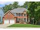 Traditional brick home featuring a manicured lawn and a two-car garage at 4058 Vinings Mill Se Trl, Smyrna, GA 30080