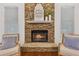 Cozy stone fireplace with decorative mantel and chairs, perfect for relaxing evenings at 4058 Vinings Mill Se Trl, Smyrna, GA 30080