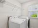 Bright laundry room features modern washer and dryer with window view at 4058 Vinings Mill Se Trl, Smyrna, GA 30080