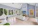 This open sunroom has a vaulted ceiling, a ceiling fan, and large windows with beautiful outside views at 4058 Vinings Mill Se Trl, Smyrna, GA 30080