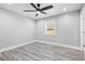 Bedroom with neutral walls, window, ceiling fan, recessed lighting, and beautiful gray wood-look flooring at 5109 Dogwood Hills Dr, Sugar Hill, GA 30518