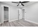 Light gray bedroom with a modern ceiling fan, closet with storage, and gray wood-look flooring at 5109 Dogwood Hills Dr, Sugar Hill, GA 30518