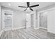 Stylish bedroom with an ensuite bath, closet, neutral walls, ceiling fan, and gray wood-look flooring at 5109 Dogwood Hills Dr, Sugar Hill, GA 30518