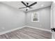 Neutral bedroom features sleek fan, light gray walls, and durable gray wood-look flooring at 5109 Dogwood Hills Dr, Sugar Hill, GA 30518
