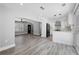 Open-concept living and kitchen area with sleek gray floors, modern lighting, and white cabinets at 5109 Dogwood Hills Dr, Sugar Hill, GA 30518