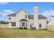 The back exterior view of this two-story home features an expansive lawn and patio area at 4207 Fortune Pt, South Fulton, GA 30349