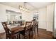 Elegant dining room with dark wood table, seating for six, and stylish lighting fixture at 4207 Fortune Pt, South Fulton, GA 30349