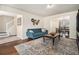 Comfortable living room featuring hardwood floors, a blue sofa, and an adjacent dining area at 4207 Fortune Pt, South Fulton, GA 30349