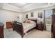 Cozy main bedroom featuring tray ceilings, wood furniture, neutral walls, and unique art at 4207 Fortune Pt, South Fulton, GA 30349