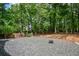 The backyard features a rock ground cover, fire pit and view of the surrounding trees at 615 Woodwork Way, Roswell, GA 30076