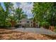 View of the home's backyard including the stone ground, gazebo, brick chimney and green trees at 615 Woodwork Way, Roswell, GA 30076