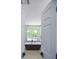Bathroom with a freestanding tub beneath a window, offering a tranquil bathing experience at 615 Woodwork Way, Roswell, GA 30076