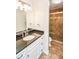 This bathroom has a black granite countertop, white cabinets, and tiled shower at 615 Woodwork Way, Roswell, GA 30076