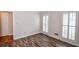 Empty bedroom featuring wood floors and windows with white shutters at 615 Woodwork Way, Roswell, GA 30076