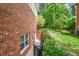 A walkway flanks the side of this brick home and features various green plants and flowers at 615 Woodwork Way, Roswell, GA 30076