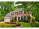 Beautiful two-story brick home with lush landscaping and mature trees providing ample shade at 615 Woodwork Way, Roswell, GA 30076