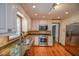 Bright kitchen boasts stainless appliances, tile backsplash, granite counters, wood floors and recessed lighting at 615 Woodwork Way, Roswell, GA 30076