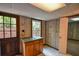 Unfinished room with wood paneled walls, linoleum floors, window, and access to the backyard at 615 Woodwork Way, Roswell, GA 30076