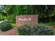 Brick neighborhood sign reading 'Woodfall', surrounded by lush greenery and mature trees at 615 Woodwork Way, Roswell, GA 30076