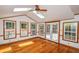 Bright sunroom features wood floors, skylights, ceiling fan, windows and French doors to deck at 615 Woodwork Way, Roswell, GA 30076