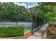 Fenced community tennis courts with a view of the court, landscaping, and trees at 615 Woodwork Way, Roswell, GA 30076