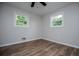 A bright and airy bedroom featuring hard wood floors and two large windows at 6213 Cherry Ln, Douglasville, GA 30134