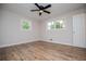 Bright bedroom with two windows, ceiling fan, and wood flooring at 6213 Cherry Ln, Douglasville, GA 30134