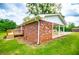 Home featuring a brick exterior, covered carport, manicured lawn, and a cozy wooden deck at 6213 Cherry Ln, Douglasville, GA 30134