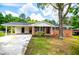 Charming brick home featuring a carport, black shutters, and a well-maintained front yard with mature trees and blooming shrubs at 6213 Cherry Ln, Douglasville, GA 30134