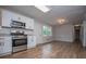 Updated kitchen featuring stainless steel appliances, white cabinets, and wood flooring at 6213 Cherry Ln, Douglasville, GA 30134