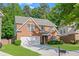 Attractive two-story brick house featuring a lush green lawn, double garage, and neat landscaping, showcasing curb appeal at 4353 Pond Edge Rd, Snellville, GA 30039