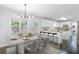 Open kitchen and dining area with modern lighting, white cabinets, and stainless appliances at 4353 Pond Edge Rd, Snellville, GA 30039