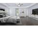 Spacious primary bedroom with dark hardwood floors, TV, ceiling fan, and access to an ensuite bathroom at 4353 Pond Edge Rd, Snellville, GA 30039