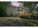 View of a two-story home's backyard featuring a large wooden deck, stairs, patio area, and lush green trees at 5702 Brynwood Nw Cir, Acworth, GA 30101