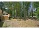 An expansive backyard with mature trees and a wooden deck is accessible by stairs at 5702 Brynwood Nw Cir, Acworth, GA 30101