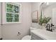 Well-lit bathroom boasts a modern vanity, stylish mirror, and a window with a view of lush greenery at 5702 Brynwood Nw Cir, Acworth, GA 30101