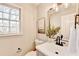 Charming half bathroom features a stylish sink, modern faucet, and decorative mirror at 5702 Brynwood Nw Cir, Acworth, GA 30101