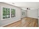 Bedroom featuring hardwood floors, two bright windows overlooking lush greenery, and a ceiling fan at 5702 Brynwood Nw Cir, Acworth, GA 30101