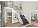 Bright entryway with a staircase featuring black metal railings, hardwood floors, and a view into the dining room at 5702 Brynwood Nw Cir, Acworth, GA 30101