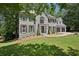 Elegant two-story home with gray brick, black shutters, and a lush green lawn surrounded by trees at 5702 Brynwood Nw Cir, Acworth, GA 30101