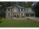 Charming brick front exterior with well-manicured lawn, mature trees, and a two-car garage at 5702 Brynwood Nw Cir, Acworth, GA 30101
