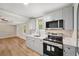 This modern kitchen features gray cabinets and stainless appliances, with a view into the living space at 5702 Brynwood Nw Cir, Acworth, GA 30101