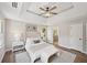 Spacious main bedroom boasts a tray ceiling, ceiling fan, and views of the backyard at 5702 Brynwood Nw Cir, Acworth, GA 30101