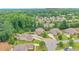 Aerial view of a residential neighborhood showcasing well-manicured lawns, mature trees, and beautifully landscaped properties at 7045 Parrish Way, Cumming, GA 30040