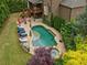Aerial view of a backyard with pool, patio, fire pit and seating area with lush landscaping at 7045 Parrish Way, Cumming, GA 30040