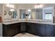 Bathroom vanity featuring granite counters, dark wood cabinets, and large mirrors at 7045 Parrish Way, Cumming, GA 30040
