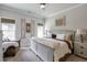Bedroom with neutral colors, a large bed, and a sitting chair at 7045 Parrish Way, Cumming, GA 30040