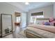 Bright bedroom with a large bed, a floor mirror, and a view of an additional room at 7045 Parrish Way, Cumming, GA 30040