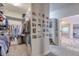 Walk-in closet with built-in shelving, shoe racks, and door leading to bathroom at 7045 Parrish Way, Cumming, GA 30040