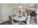 Charming dining area features a white table, tufted chairs, and a view into the living room at 7045 Parrish Way, Cumming, GA 30040